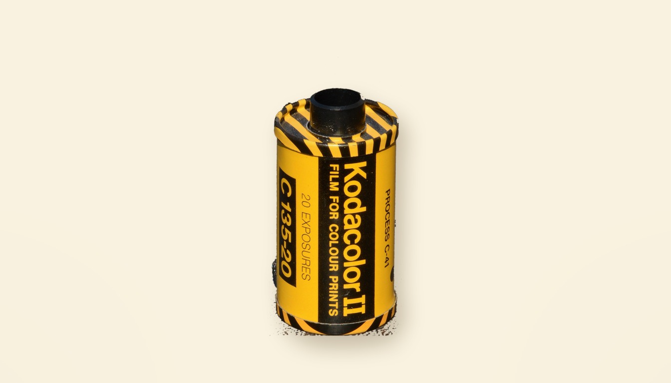 A Kodacolor II 35mm film cassette from the 1970s, yellow with black stripes