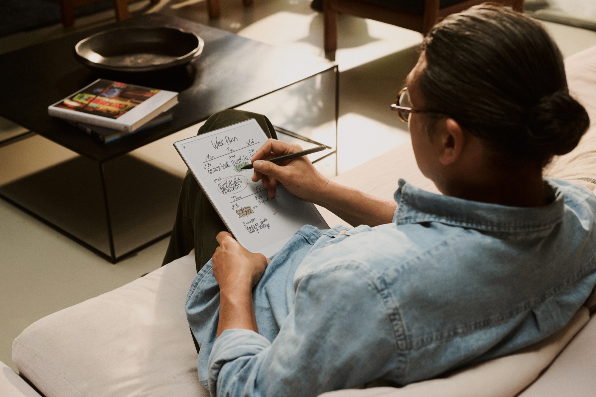 Over-the-shoulder view of a person writing a weekly plan on a reMarkable Paper Pro tablet.